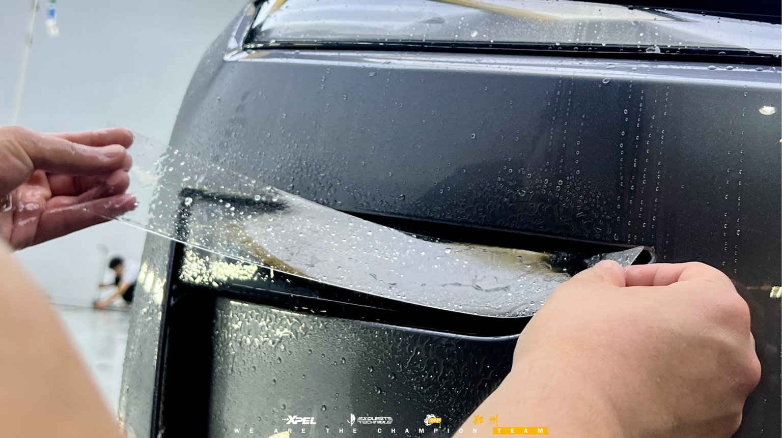 技师在奥迪 A7L 引擎盖边缘做膜体收边