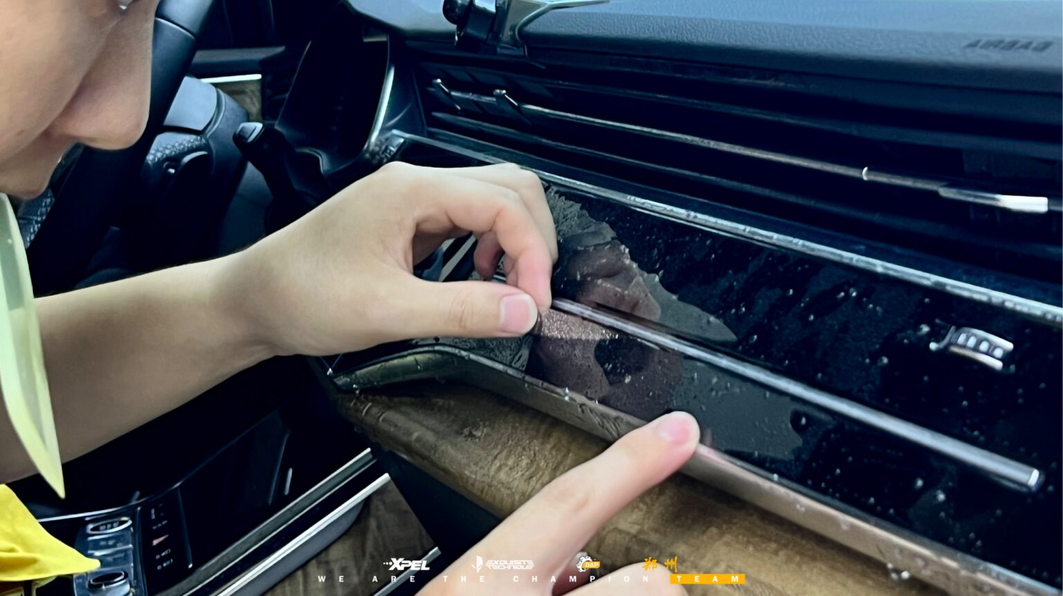 技师用刮板压实奥迪 Q7 前门框边缘的膜体
