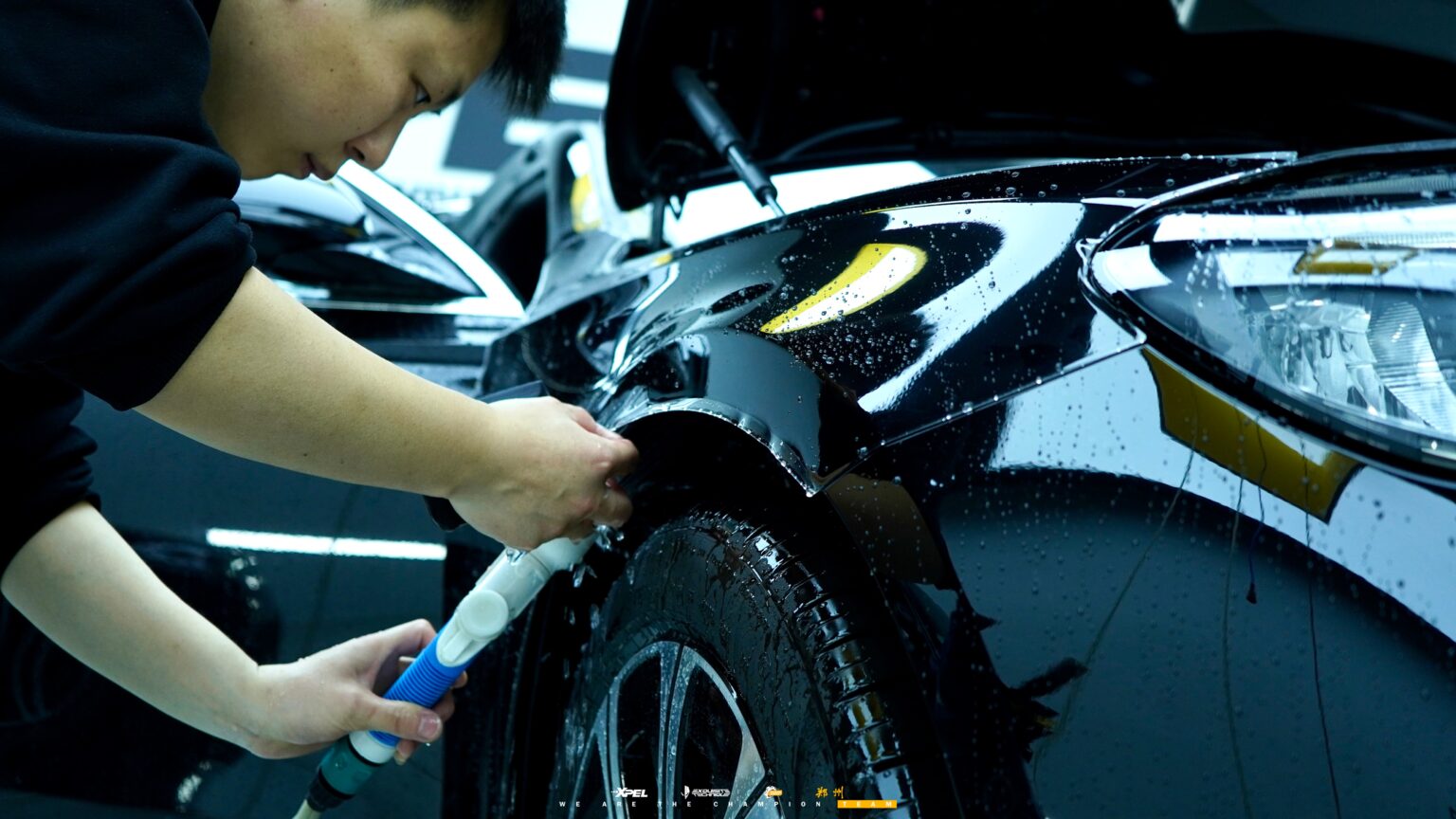 技师在奔驰 E300 后视镜壳处贴合膜体