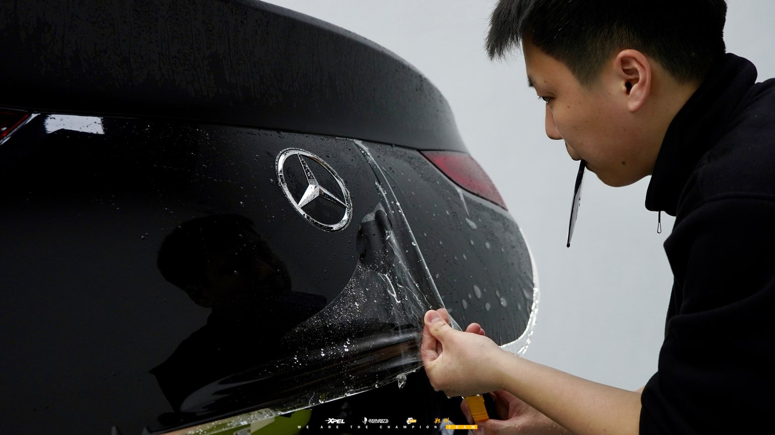 技师在奔驰 GLE 车尾 Mercedes 车标处贴膜