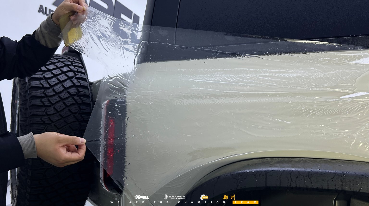 技师在福特烈马尾门与备胎架区域贴合膜体
