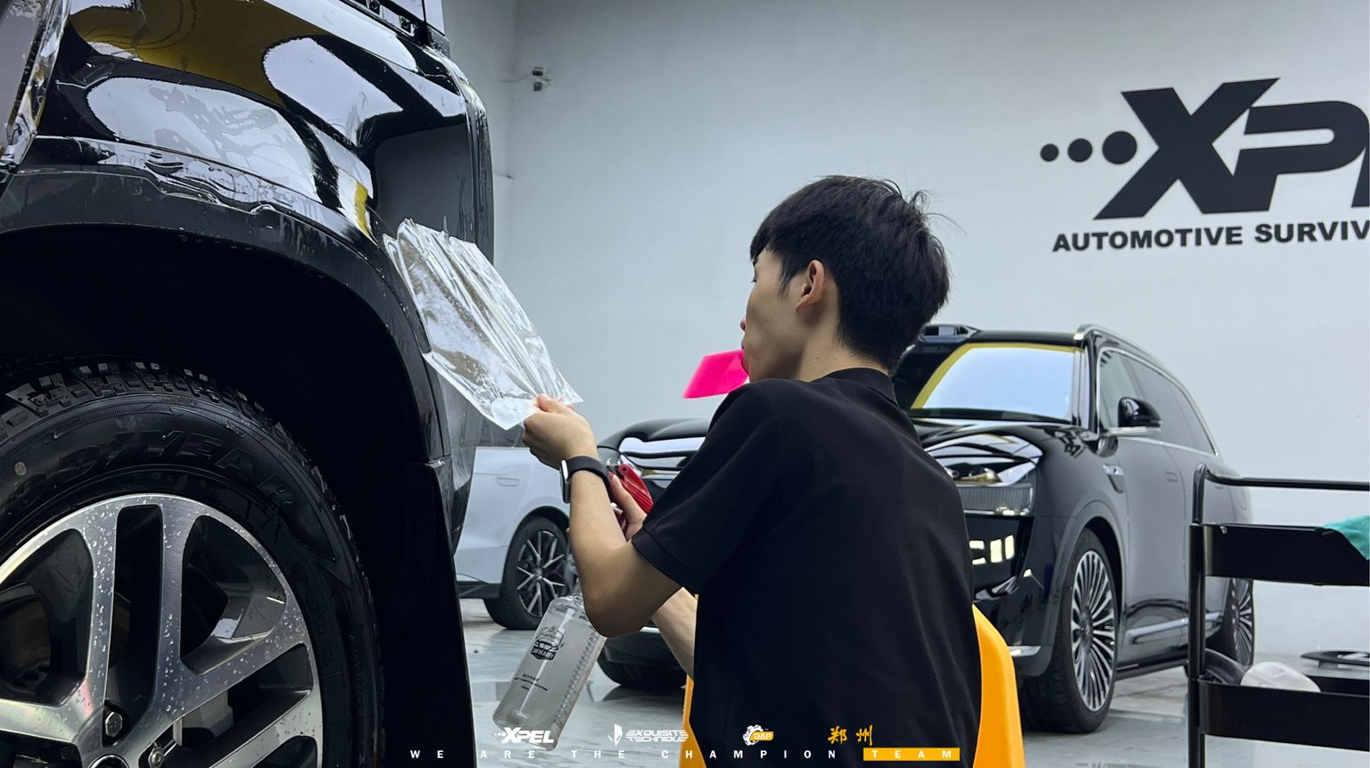 技师在路虎卫士车身后部贴合膜体