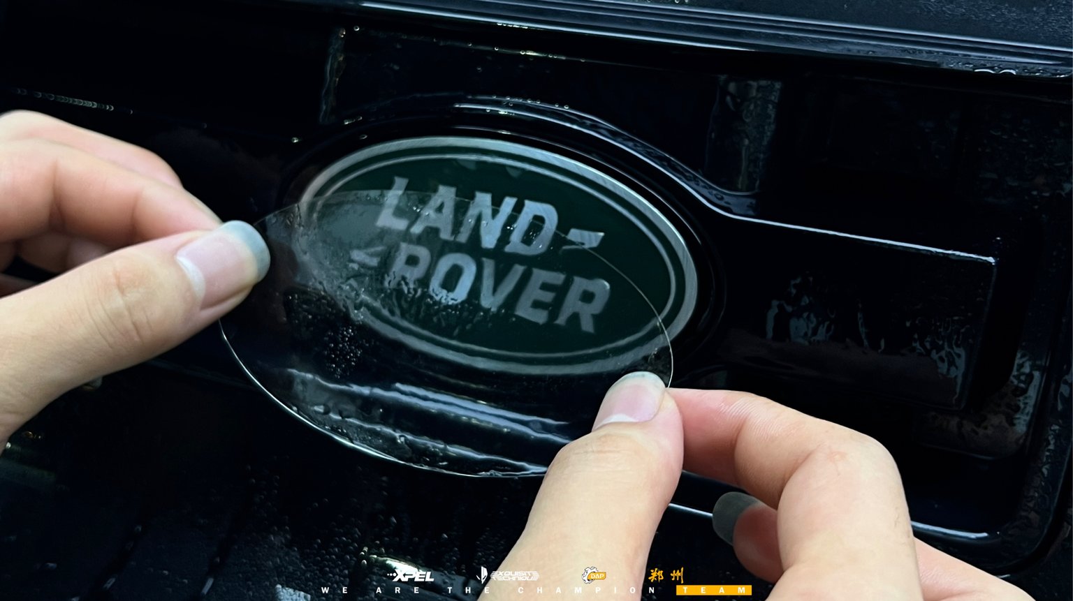 路虎卫士 LAND ROVER 绿色椭圆车标,技师正在贴膜处理