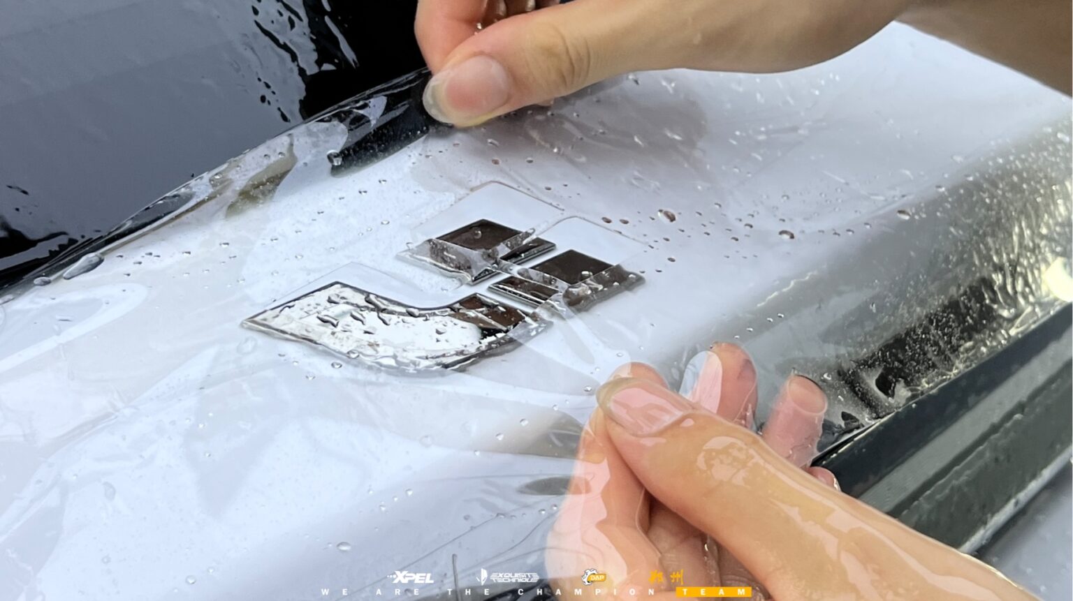 技师在理想 i8 白色漆面贴膜,可见膜体与刮板