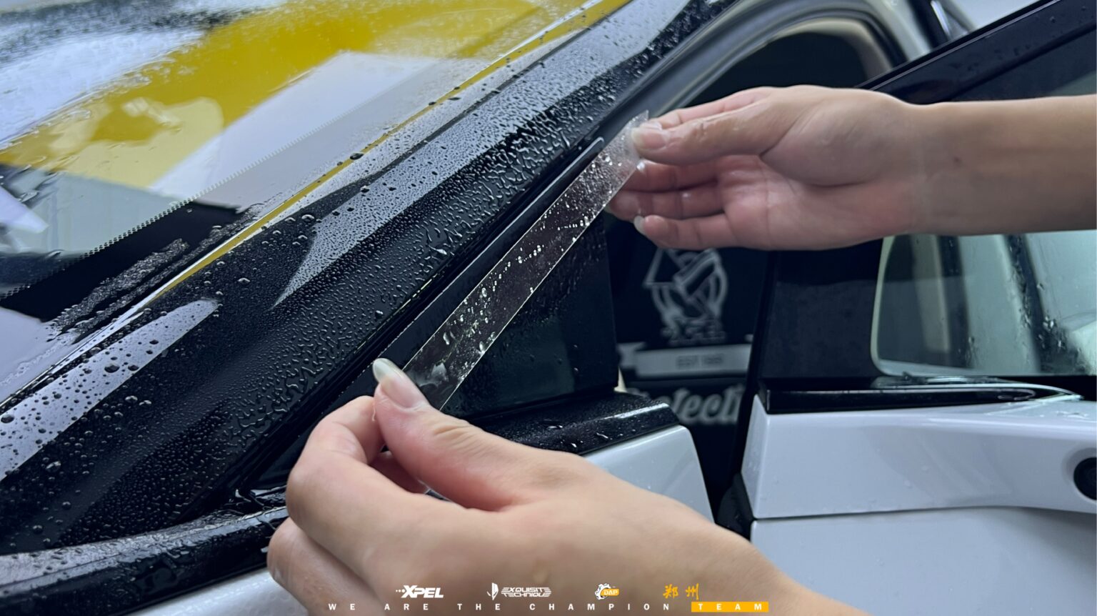 技师在理想 i8 前风挡边缘贴合膜体