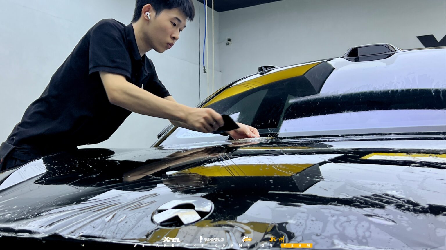 技师在蔚来 ET5T 后备箱盖处贴合膜体