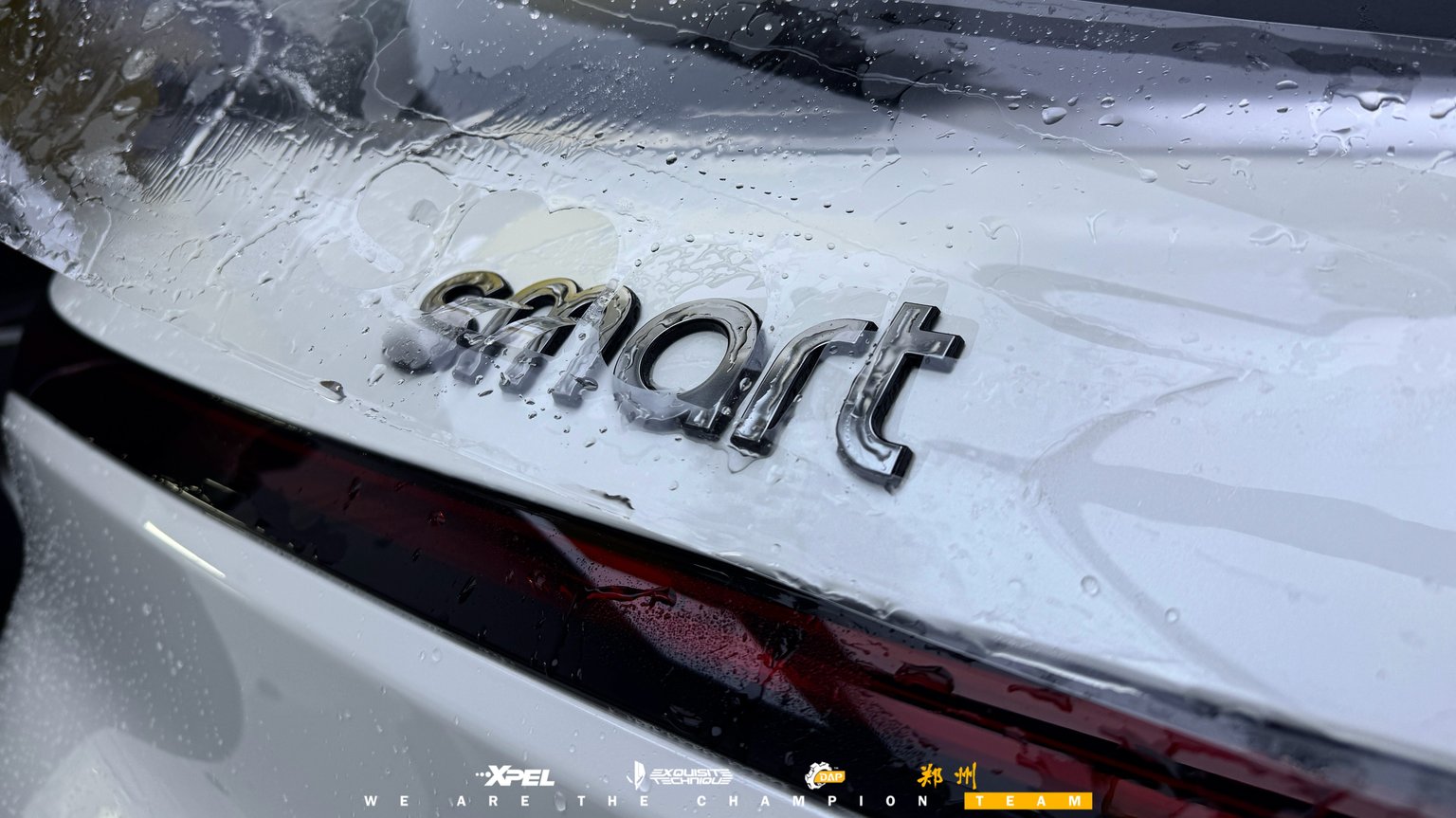 Smart 精灵引擎盖「smart」字标贴膜特写,膜面水痕清晰