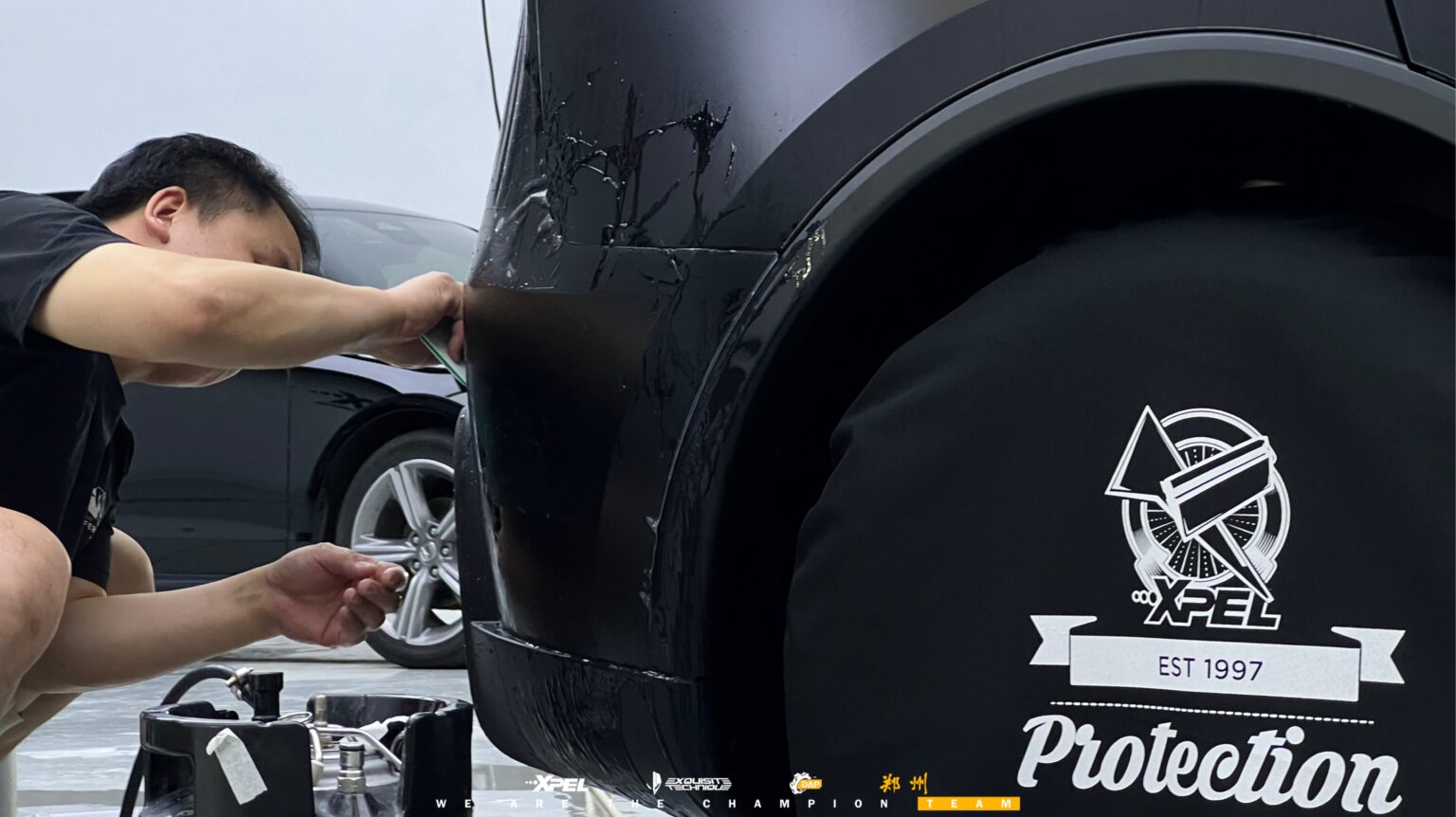 技师在特斯拉 Model Y 轮眉处贴合膜体