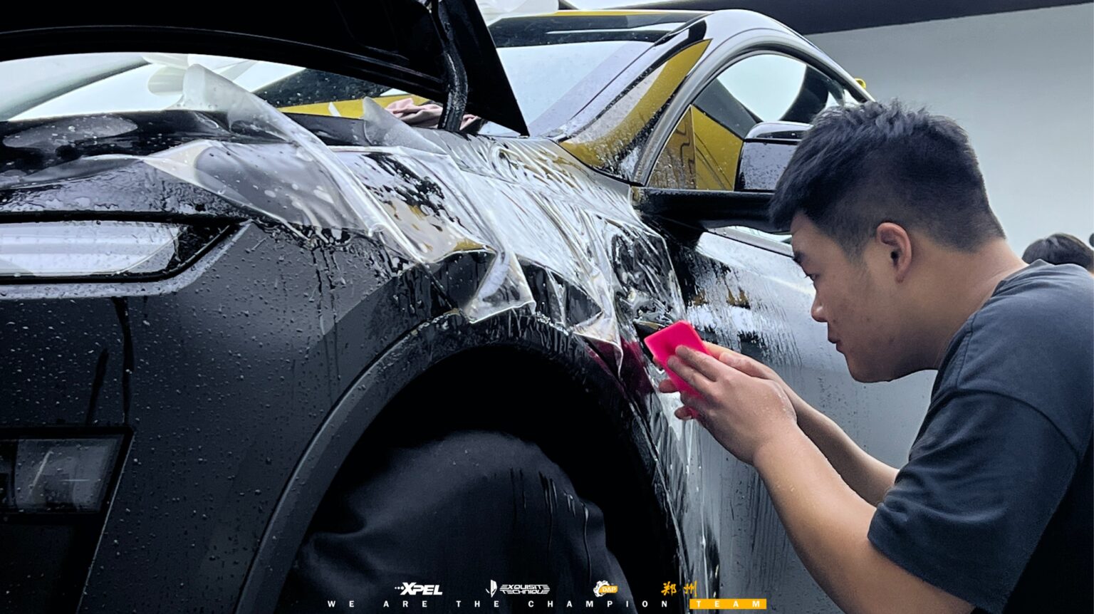 技师在特斯拉 Model Y 后翼子板处施工,可见哑光黑车身