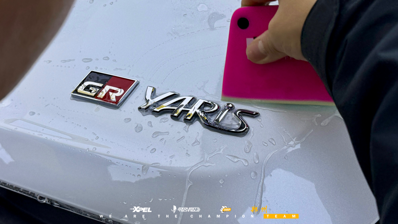 丰田雅力士 GR「GR Yaris」字标贴膜特写,技师用粉色刮板压实