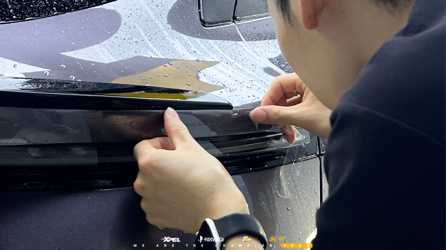 技师在极氪 007GT 侧窗镀铬饰条处贴合膜体